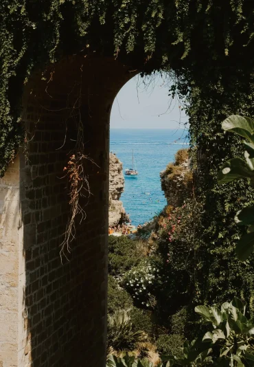 Calle de un pueblo blanco en la región de Puglia con flores y arquitectura mediterránea, parte de los viajes de autor de Nuviatrip.