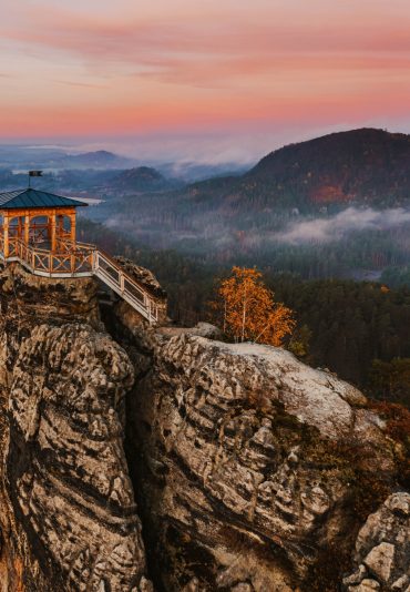 Jetrichovice, Czech Republic - Aerial panoramic view of Mariina Vyhlidka (Mary's view) lookout with foggy Czech autumn landscape and colorful pink sunrise sky in Bohemian Switzerland region